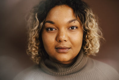 Portrait of young woman wearing turtleneck in studio