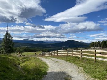 Empty road along landscape and mountains against sky