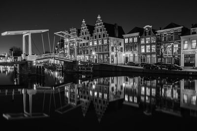 Reflection of illuminated bridge and buildings in canal at night