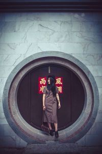 Full length of woman standing on bench