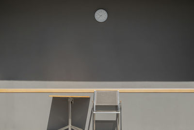 Chair and table against gray wall