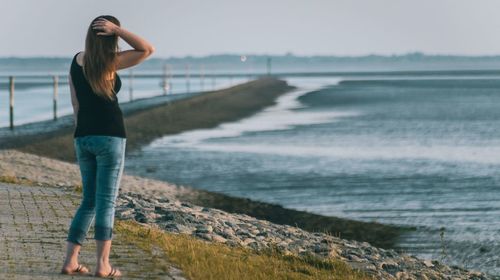 Full length of young woman standing on beach