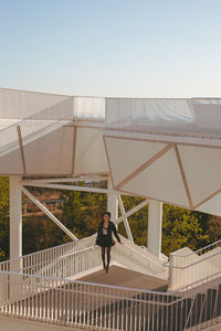 Young woman standing by railing