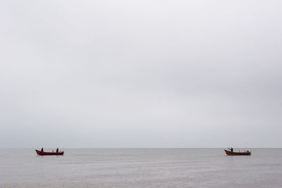 Boat sailing in sea against sky