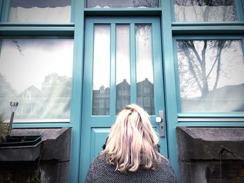 Woman sitting in front of closed door