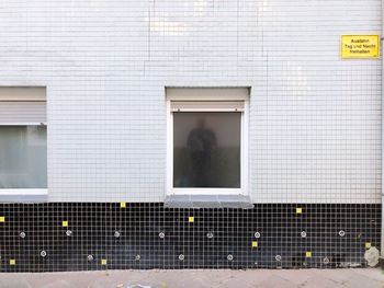 Man reflecting on window of building