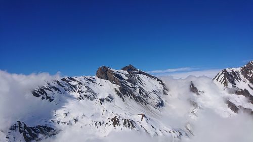 Scenic view of snowcapped mountains against clear blue sky