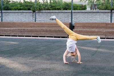 Rear view of woman exercising on field