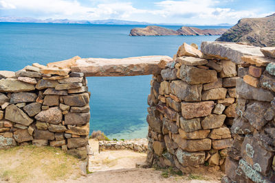 Old built structure by sea against sky