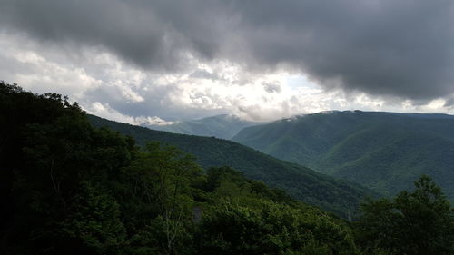 Scenic view of mountains against cloudy sky