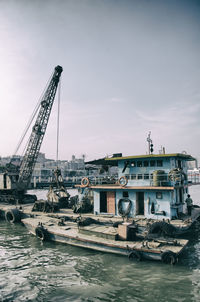 Ship moored at harbor against sky