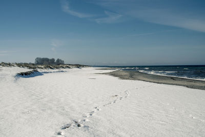 Scenic view of beach against sky during winter