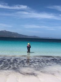 Man fishing in sea against sky