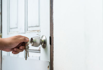 Cropped image of hand unlocking door with key