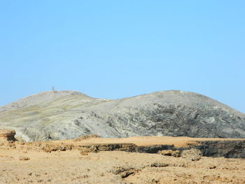 Scenic view of arid landscape against clear blue sky