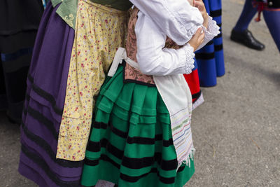 Low section of people in traditional clothing standing on road