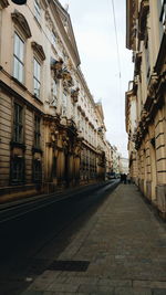 Empty street amidst buildings against sky