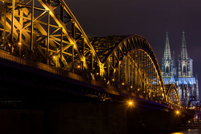 Illuminated bridge against sky at night