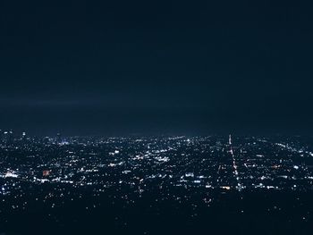 High angle view of illuminated cityscape against sky at night