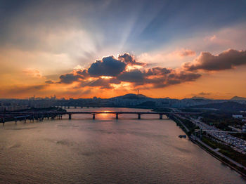 Bridge over river against sky during sunset