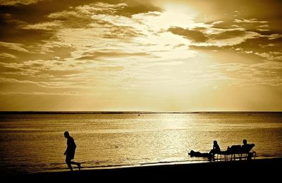 Silhouette of man in sea at sunset