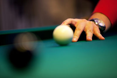 Cropped hand of man playing pool