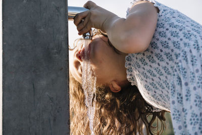 Girl drinking water from standpipe