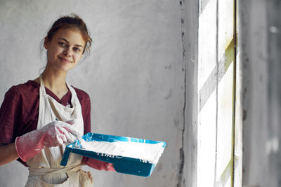 Young woman standing against wall