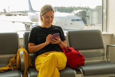 Young woman using mobile phone while sitting in bus