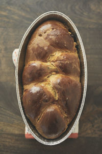 Overhead view of challah bread in container on table at home