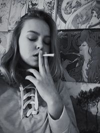 Close-up of young woman smoking on bed