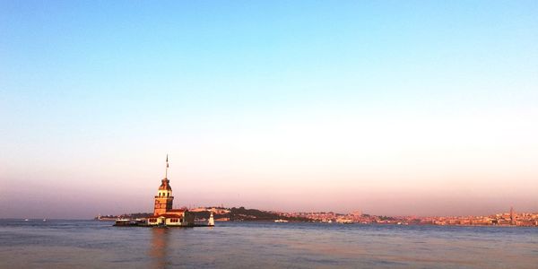 Scenic view of sea and buildings against sky during sunset