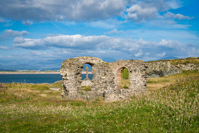 Old ruin on field against sky