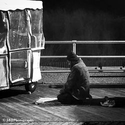 Rear view of man working on railing