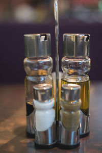 Close-up of salt and pepper shaker with cooking oil in bottles on table