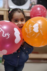 Portrait of smiling girl holding balloons