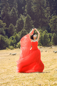 Woman wearing mask while standing on field at forest