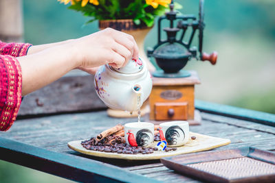 Cropped hand of woman holding coffee on table