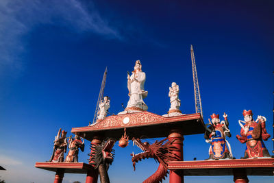 Low angle view of statue against blue sky