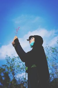 Low angle view of man standing against sky