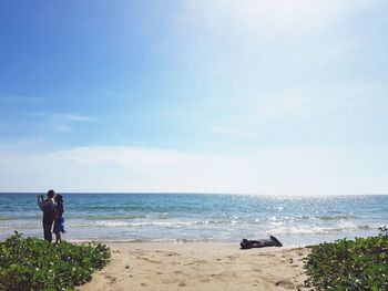 People on beach against sky