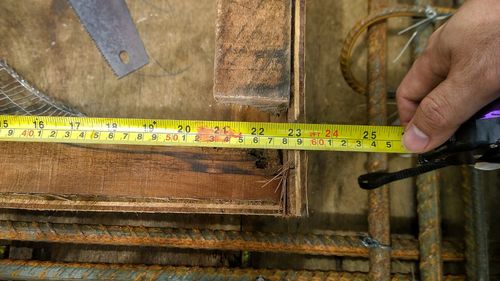 Cropped hand measuring wood