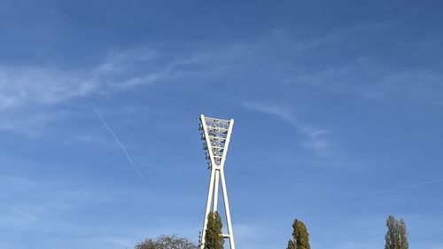 Low angle view of communications tower against blue sky