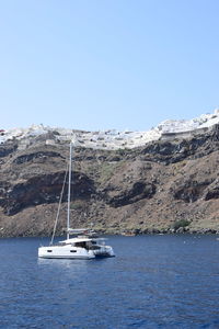 Sailboat sailing on sea against clear sky