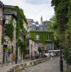 Houses by street in town against sky