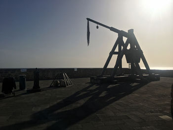 Silhouette people by sea against clear sky during sunset