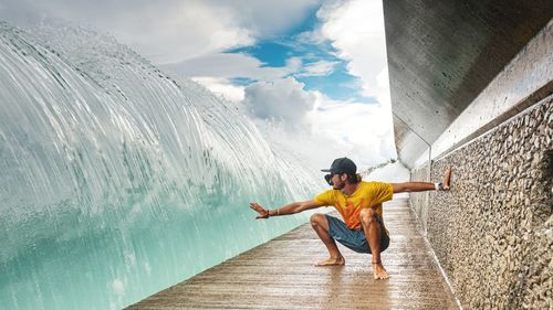 Full length of young man in water against sky