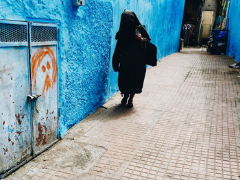 Rear view of woman walking on footpath