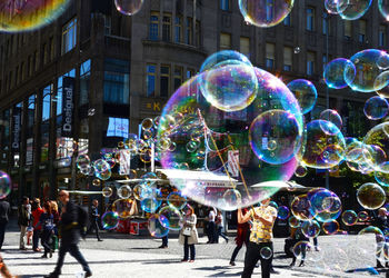 Bubbles with people on street in city