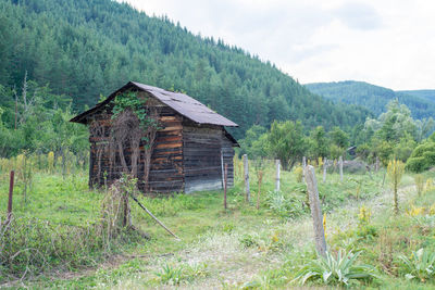 House on field against trees and mountains